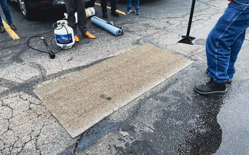 Reparación vial con American Road Patch en superficie de pavimento.